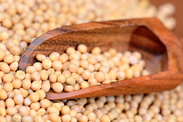 Mustard seeds in a wooden scoop