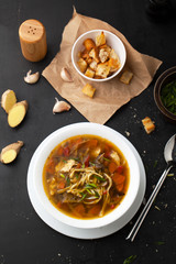 Soup with croutons, chicken, noodles and ginger