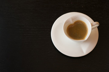 Cocoa or hot chocolate in the red circle in the shape of a heart with a red cap on a wooden background for Christmas or New Year's Eve