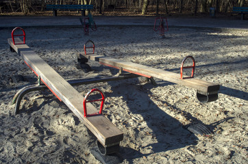 
Old playground.Vintage neglected wooden playground equipment placed in a sand.