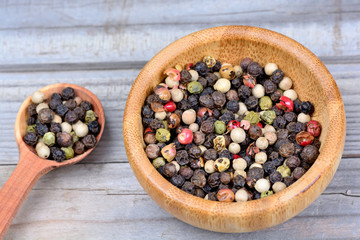 Bowl and spoon with colorful peppercorns