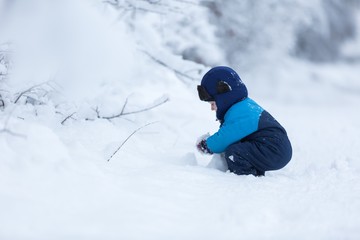 Fototapeta na wymiar Happy caucasian child playing in snow