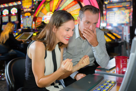 Couple playing machine in casino