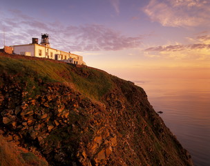 Sunset over Sumburgh Head lighthouse, built by Robert Stevenson in 1821 and now an RSPB office, Shetland Islands, Scotland