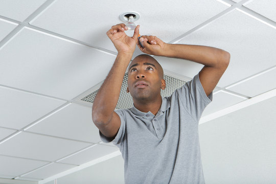 Man Changing Ceiling Lightbulb