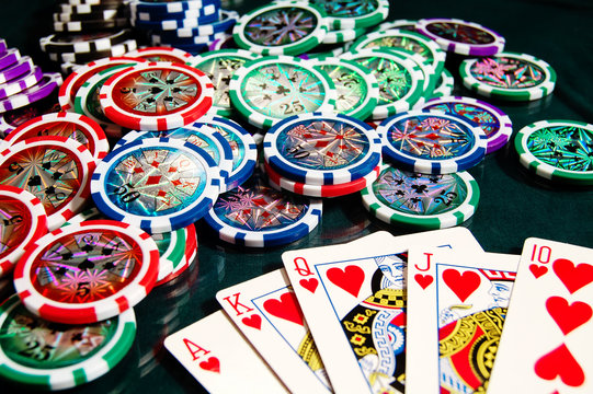 Royal flash win in poker and big heap of poker chips
