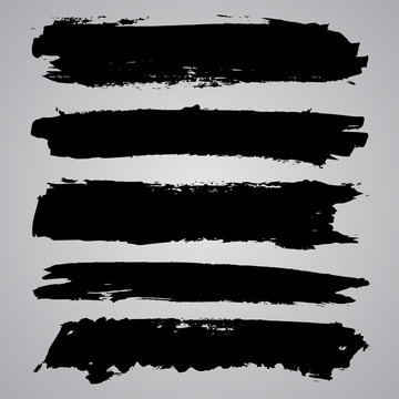 Set of black grunge brushstrokes on grey background. Abstract ha