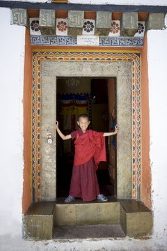Young Buddhist monk in doorway, Paro Dzong, Paro, Bhutan