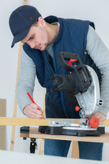 full length portrait of handsome young carpenter indoors