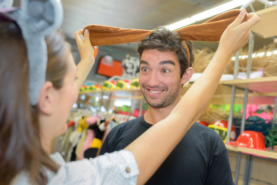 extatic couple having fun while shopping in a costume shop