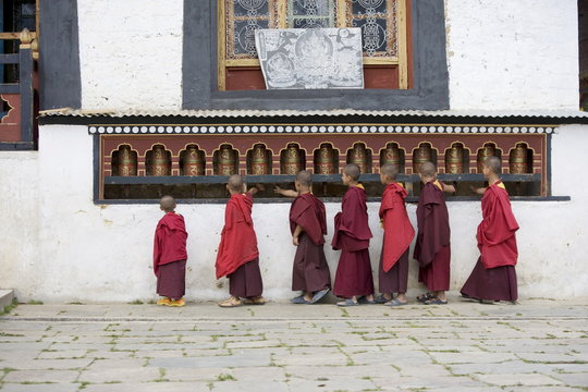 Buddhist monks turning prayer wheels, Karchu Dratsang Monastery, Jankar, Bumthang, Bhutan