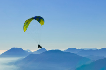 Paragliding tandem flying over the mountains. Freedom concept