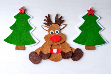 greeting card handmade christmas reindeer from felt on white wooden background