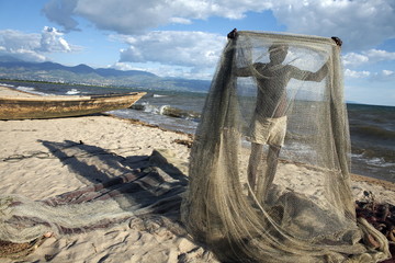 A fisherman tends his nets on Plage des Cocotiers (Coconut Beach) also known as Saga Beach, Lake Tanganyika, Bujumbura, Burundi
