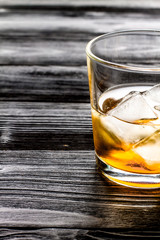 glass of whiskey on dark wooden background