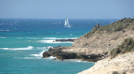 A white sailboat in the turquoise sea in Kos island in a windy day, Greece