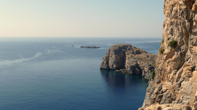 The coast of Tilos island with blue sea and big stack, Greece
