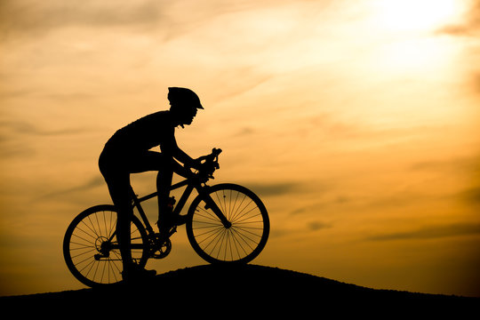 Silhouette of man on mountain bike at sunset