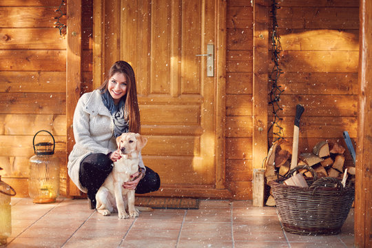 Girl With Dog In Front Of Wooden House