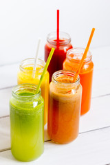 Fresh detox juices in glass bottles on white background