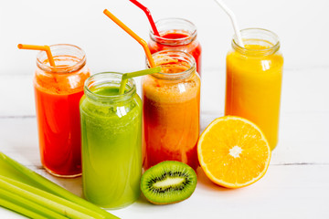 Fresh detox juices in glass bottles on white background