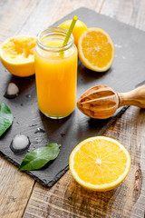 freshly squeezed orange juice in glass bottle on wooden background