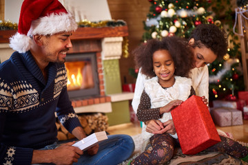 Afro American family opening Christmas present