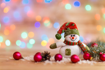cheerful snowman in knit hat and Christmas decorations 