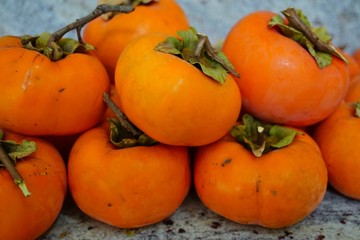 Pile of ripe orange persimmon fruit