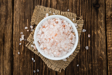 Portion of Himalayan Salt on wooden background (selective focus)