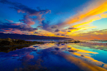 Beautiful Hawaiian sunset reflected in tide pool on the North Shore of Oahu