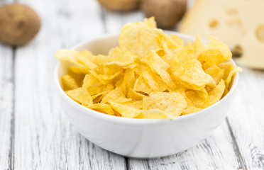 Portion of Potato Chips (Cheese and Onoion taste) on wooden back