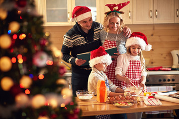 children and parents preparing cookies for Xmas. - obrazy, fototapety, plakaty