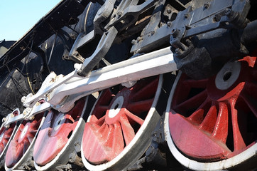 Red wheels of old USSR black steam locomotive. Wheels of an old soviet steam train