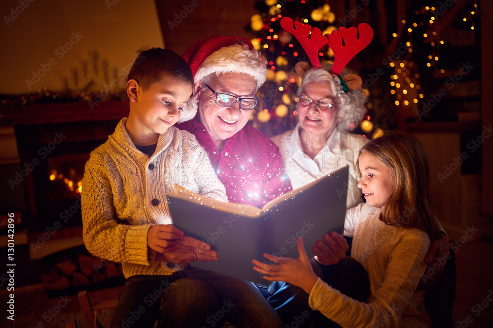 Wall mural christmas magic book and family.