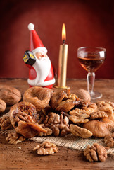 Dried figs with nuts and wine and Santa Claus candle
