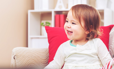 Toddler girl laughing in her living room