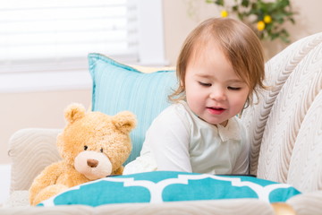 Happy toddler girl sitting with her teddy bear
