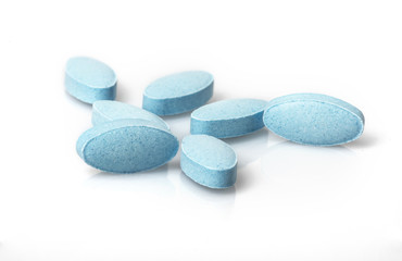 Small blue tablets spilling out of prescription container