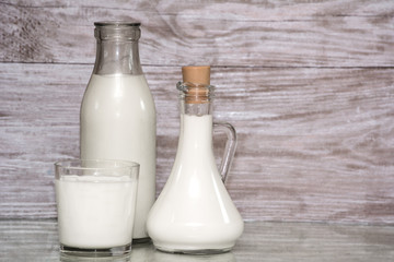 Milk in a glass. milk in a glass decanter, bottle of milk on wood background. Concept from alfaphotorus