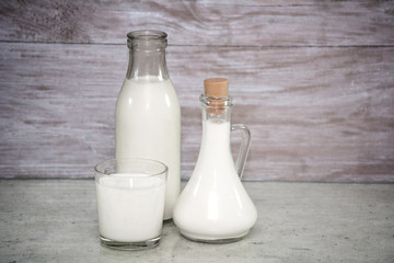 Milk in a glass. milk in a glass decanter, bottle of milk on wood background. Concept from alfaphotorus
