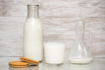 Milk in a glass. milk in a glass decanter, bottle of milk on wood background. Concept from alfaphotorus