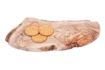 Wheat crackers on olive wood cutting board isolated on white background