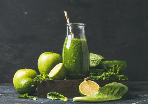 Green smoothie in glass bottle with apple, romaine lettuce, lime and mint, dark background, selective focus. Detox, dieting, clean eating, vegetarian, vegan, fitness or healthy lifestyle concept