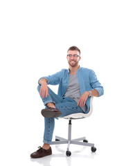 Fototapeta premium Young man sitting on the chair isolated over white background