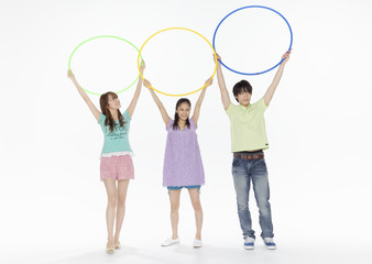 Naklejka premium Young man and women holding hula hoops