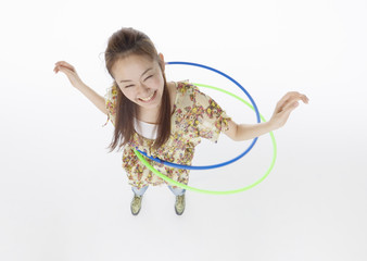 Young woman playing with hula hoops