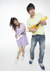Young man and woman playing the ukulele