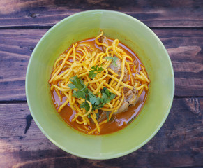 Curried Noodle Soup with Chicken (Khao Soi) in green bowl 