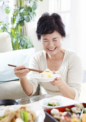 Obraz na płótnie Canvas Senior woman eating sushi